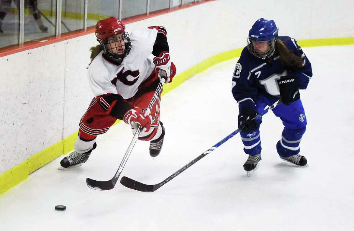 New Canaan High School's Molly Burwick races for the puck against Darien High School's Lily Christensen in the girls hockey FCIAC championship game at Terry Conners Rink in Stamford, Conn. on Saturday February 26, 2011. New Canaan won 7-1.