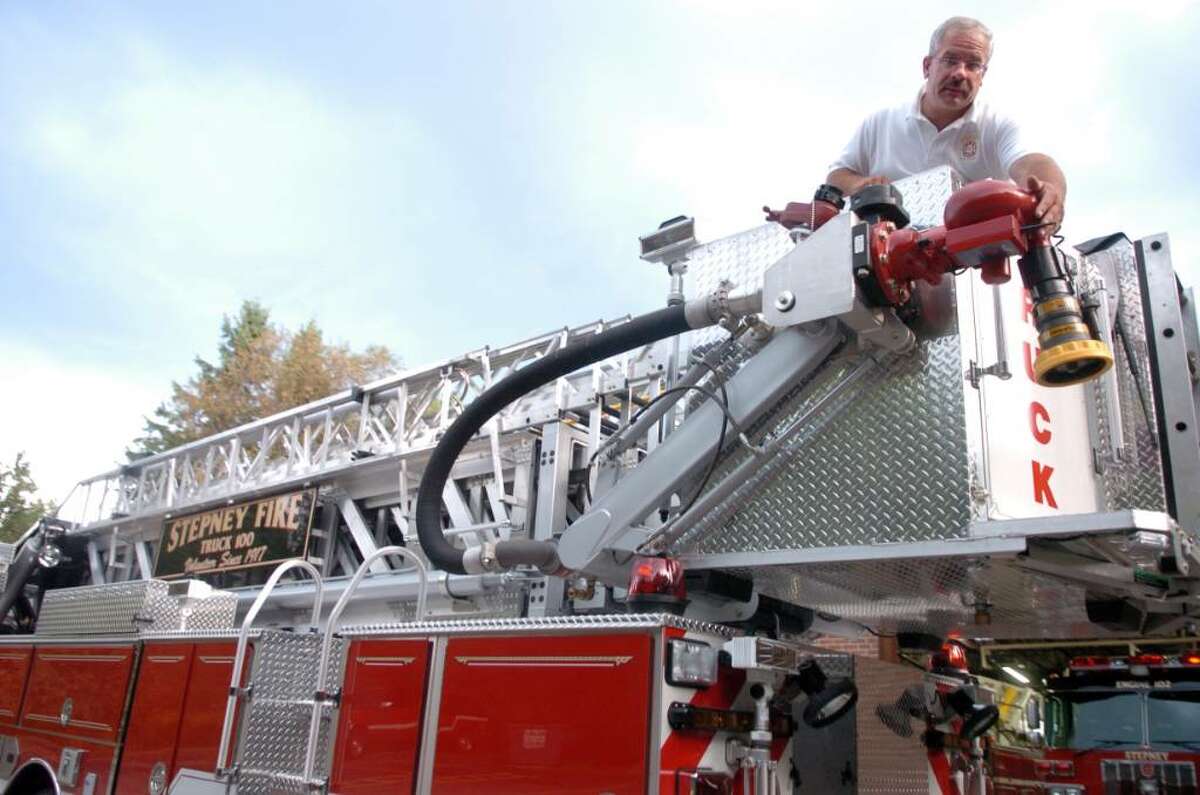 Chief Mike Klemish points out some of the new features on Stepney Volunteer Fire Company's new 2009 lader tower, one of six new trucks for the Monroe, Conn. fire company.