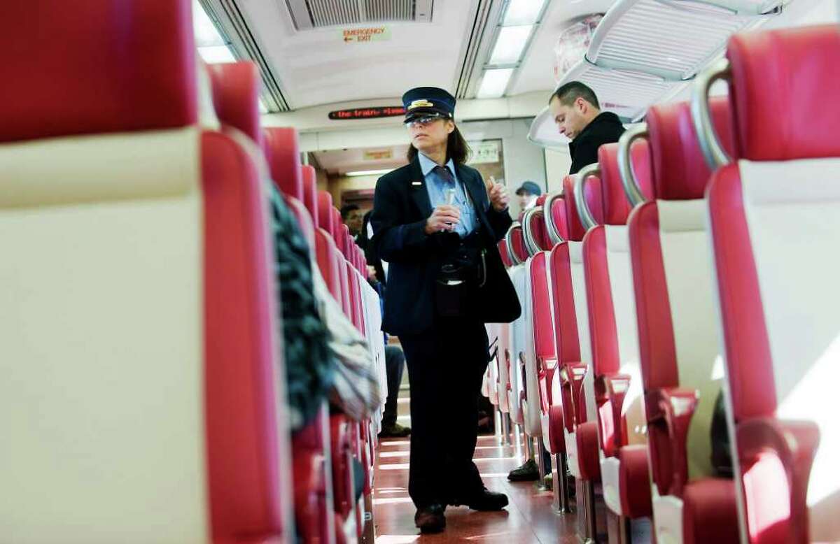 Conductor Carol Kirner checks tickets as passengers ride to Grand Central Station on the inaugural run of the new M-8 train from Stamford, Conn. on Tuesday March 1, 2011.