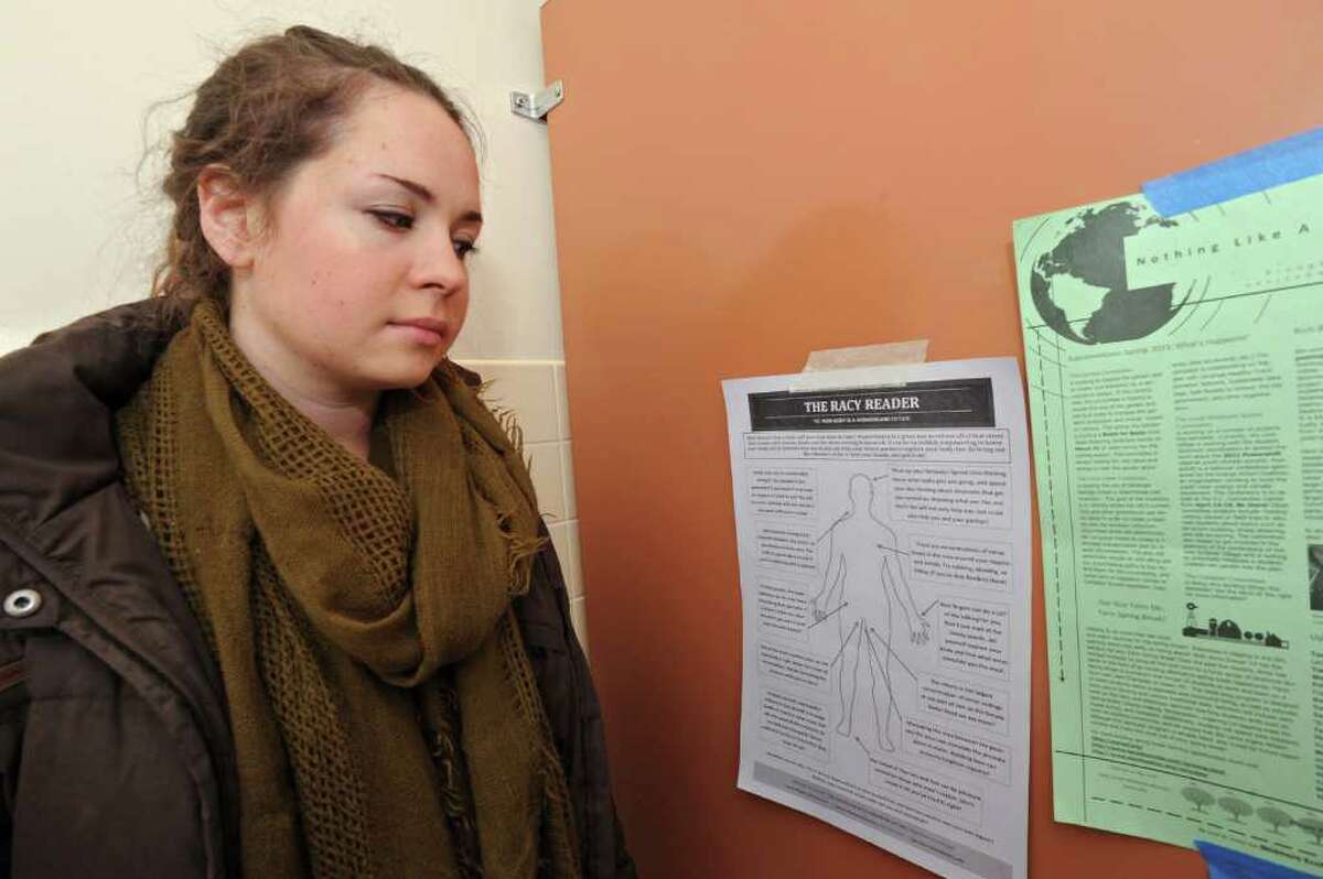 Senior Katie Wallace, 21 of Atlanta, looks at a poster about masturbation that hangs on the inside of a stall wall in a woman's bathroom in the library at Skidmore College in Saratoga Springs, NY on Wednesday, March 2, 2011. (Lori Van Buren / Times Union)