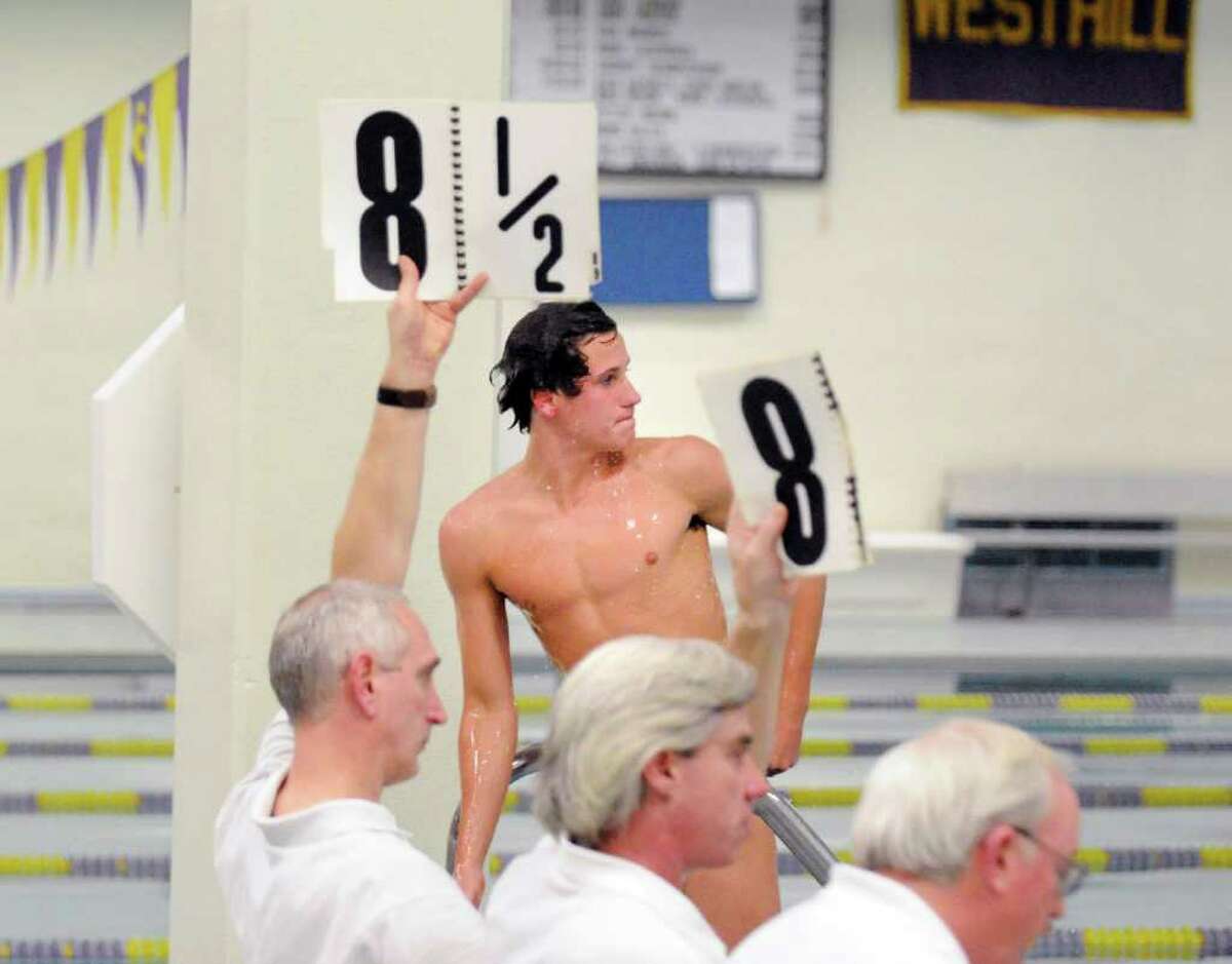 Connor Brisson of Greenwich High School looks across the pool to see his score from the other set of judges after finishing a dive during the FCIAC Diving finals at Westhill High School, Stamford, Wednesday night, March 2, 2011.