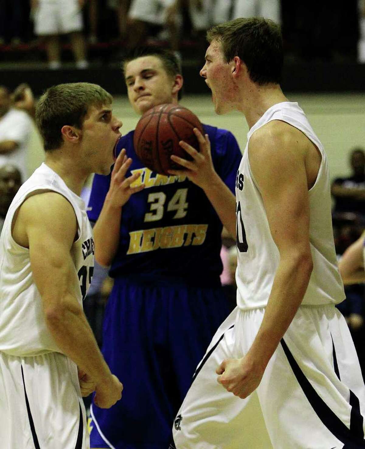 Alamo Heights' Shelby Lane (34) can only look away as Boerne Champion's David Rogers (left) reacts with teammate Dallas Quick (right) after Quick managed a put back against Alamo Heights for a score in Class 4A basketball playoffs at Littleton Gym on Wednesday, Mar. 2, 1011. Boerne Champion defeated Alamo Heights, 53-47. Kin Man Hui/kmhui@express-news.net
