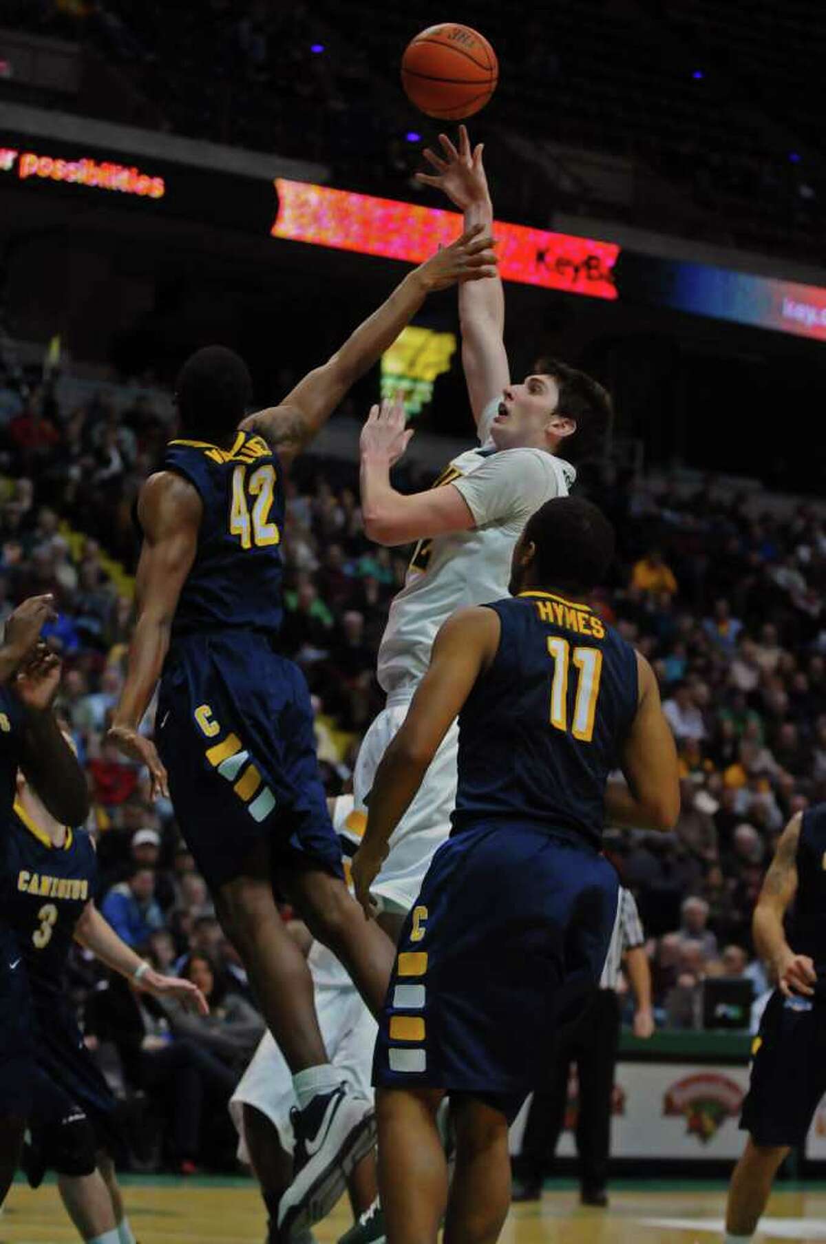 Siena's Ryan Rossiter puts up a shot over Canisius Tomas Vasquez-Simmons during the second half of Siena's 73-69 win over Canisius at the Times Union Center in Albany, NY on Monday night January 17, 2011. ( Philip Kamrass / Times Union )