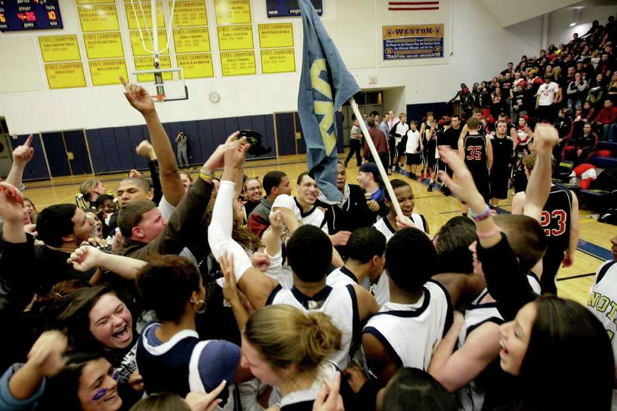 Students and fans cheer Pomperaug High School and Notre Dame Catholic High School during the SWC high school men's basketball championship at Weston High School in Weston, Conn. on March 3, 2011.