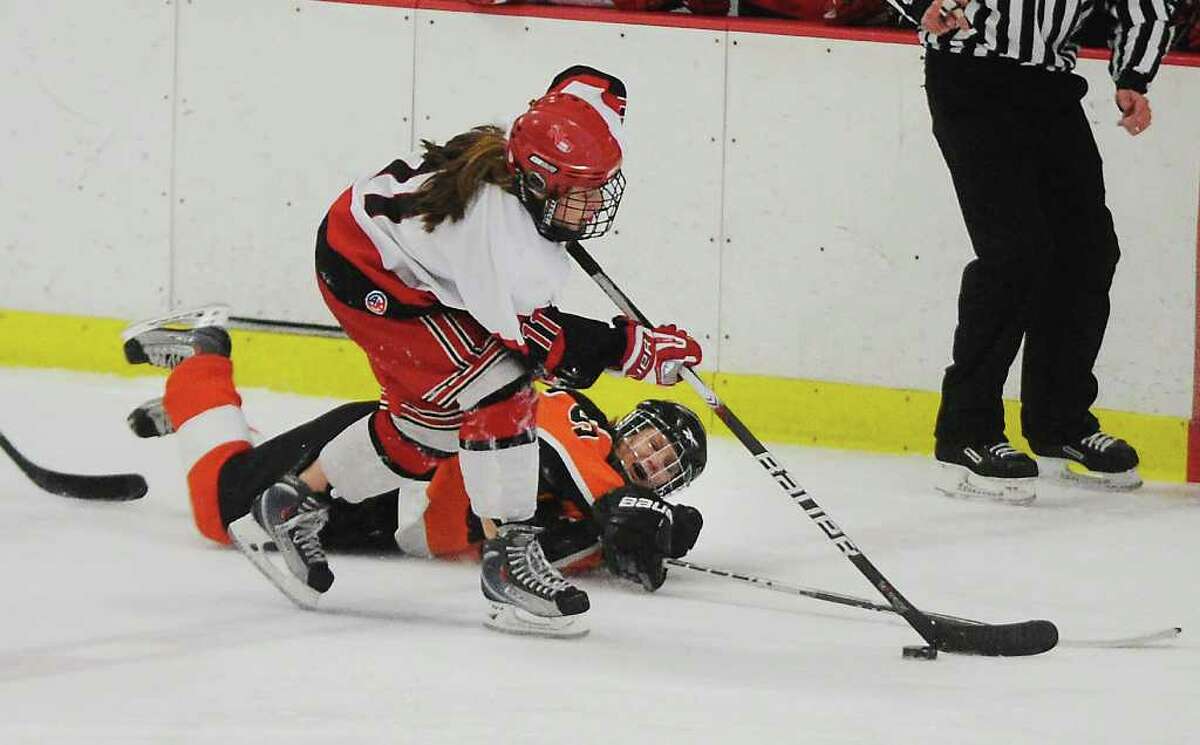 New Canaan's Holly Burwick takes the puck from Ridgefield's Erica Guider in the girls hockey state championship game at Terry Conners Rink in Stamford, Conn. on Saturday March 5, 2011.