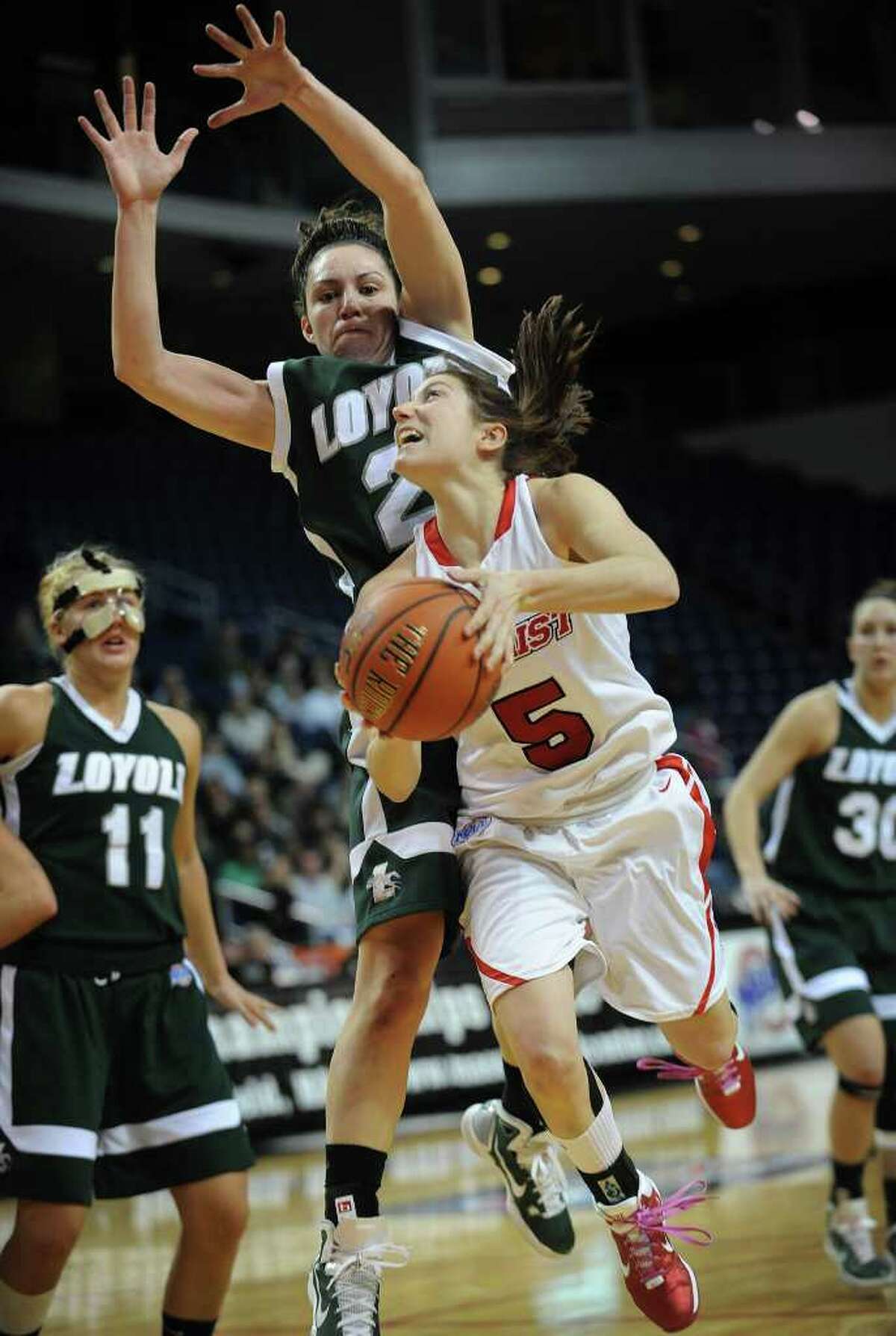 Marist's Elise Caron drives to the basket while being defended by Loyola's Katie Sheahin in the finals of the MAAC conference tournament at the Webster Bank Arena at Harbor Yard in Bridgeport on Monday, March 7, 2011. Marist won the game 63-45.