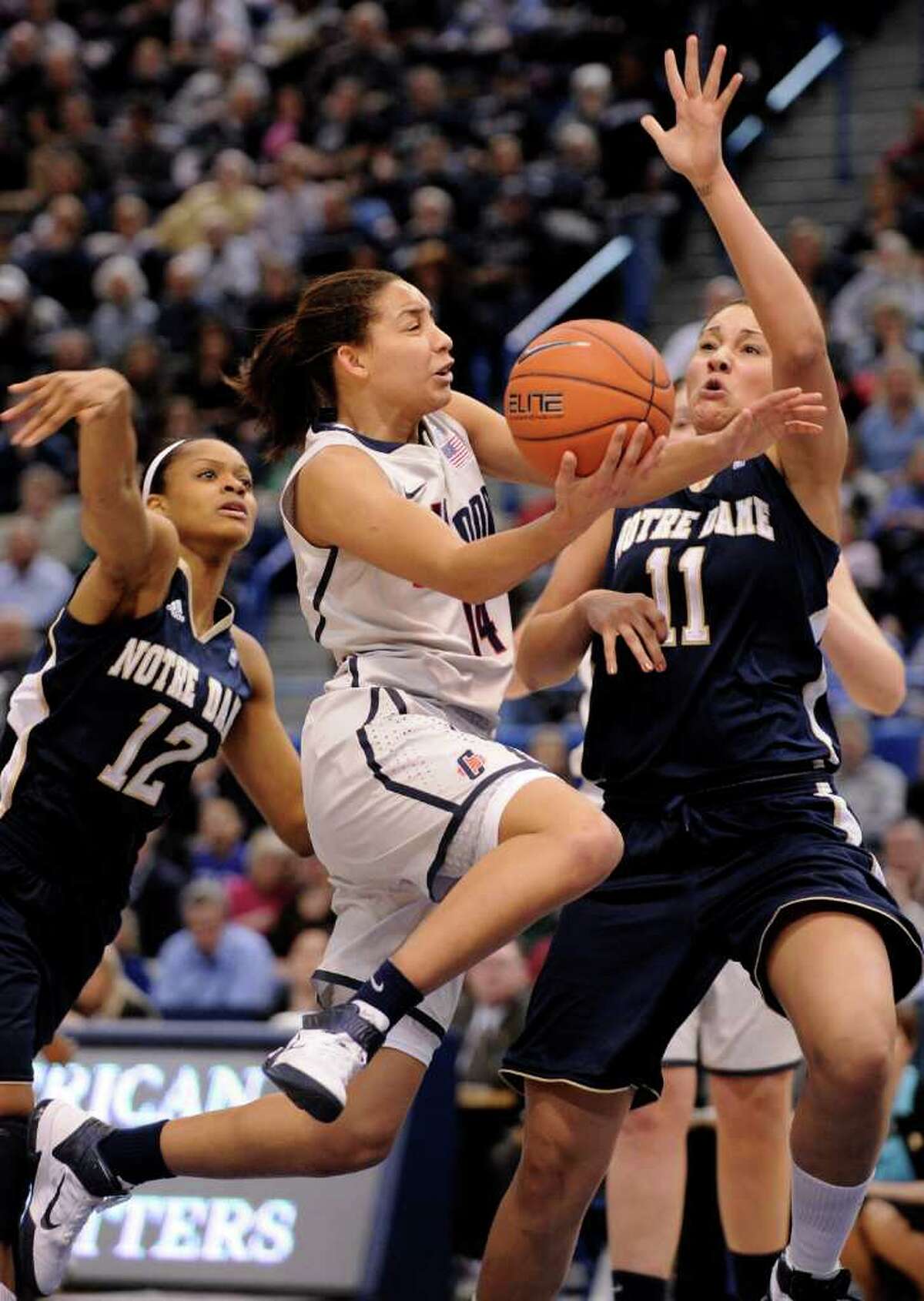 Connecticut's Bria Hartley, center, drives past Notre Dame's Frederica Miller, left, and Natalie Achonwa during the first half an NCAA college basketball game in the final of the Big East tournament in Hartford, Conn., on Tuesday, March 8, 2011. (AP Photo/Fred Beckham)