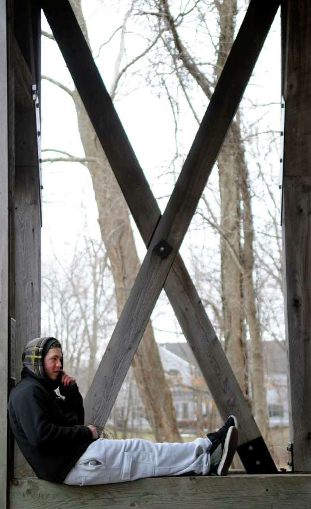 Seventeen-year-old Zack Jurewicz sits on the covered bridge at Twin Brooks Park in Trumbull Wednesday, March 9, 2011.