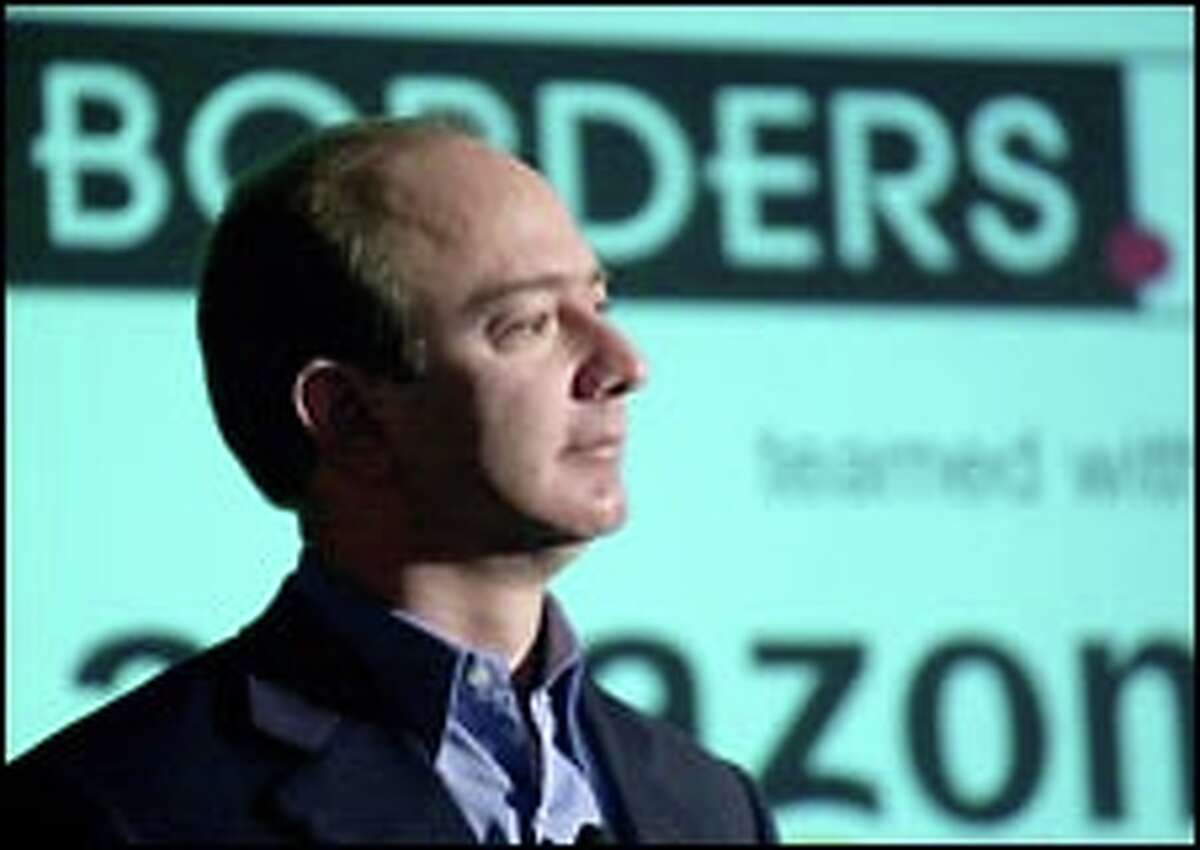 Amazon.com founder and CEO Jeff Bezos listens to reporters' questions at a news conference yesterday about the deal with Borders to operate its Internet business.