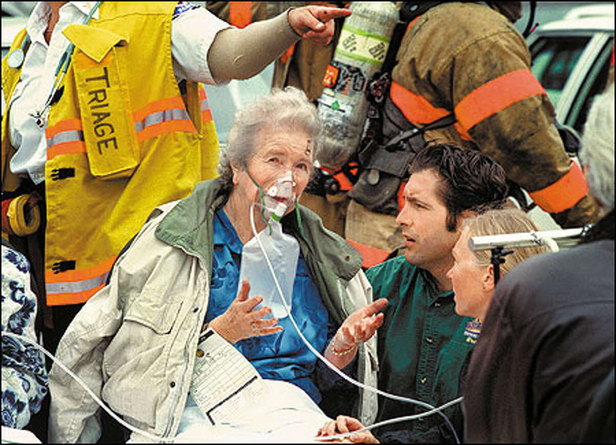 A resident breathes oxygen through a face mask at a triage center.