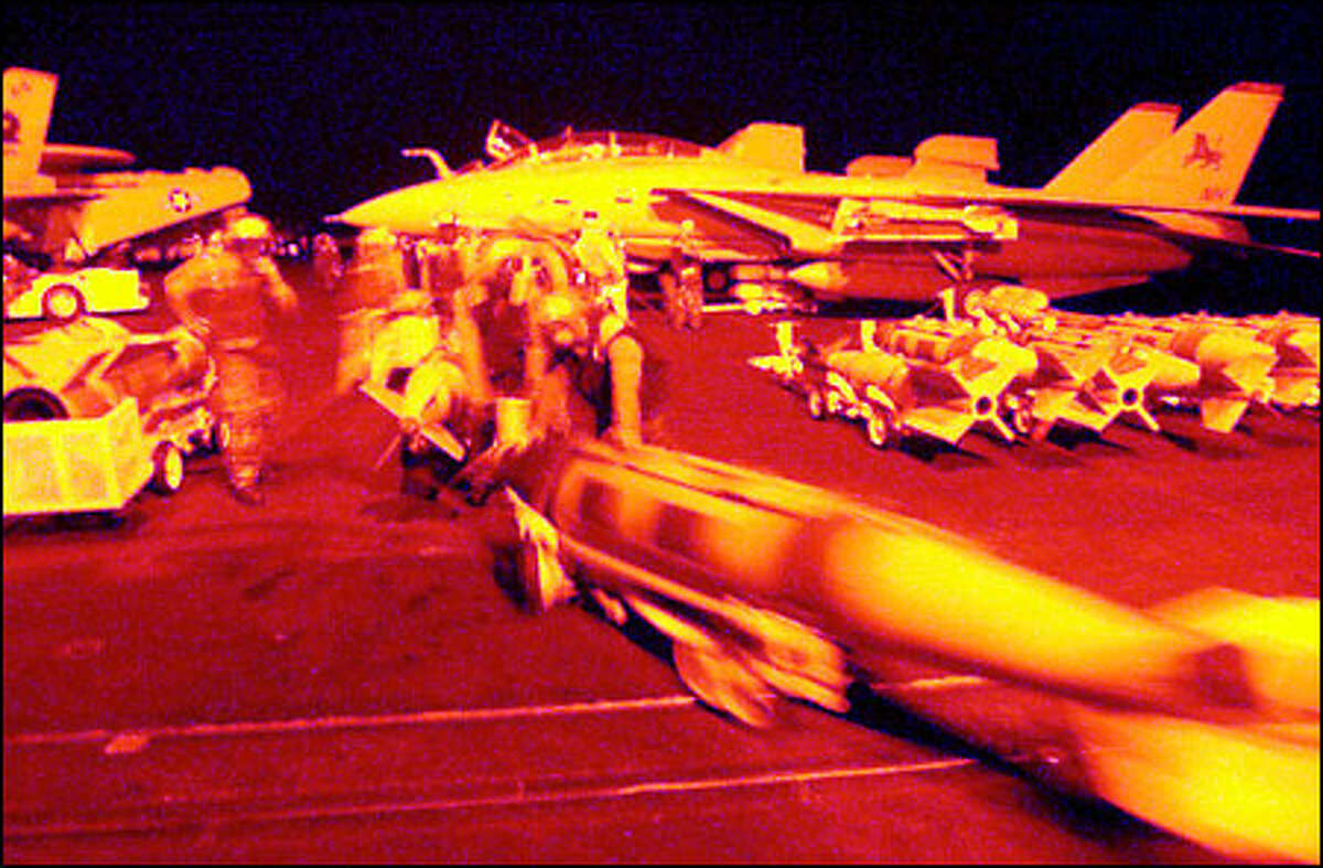 Navy specialists move a 1,000-pound bomb on the Bremerton-based aircraft carrier USS Carl Vinson.