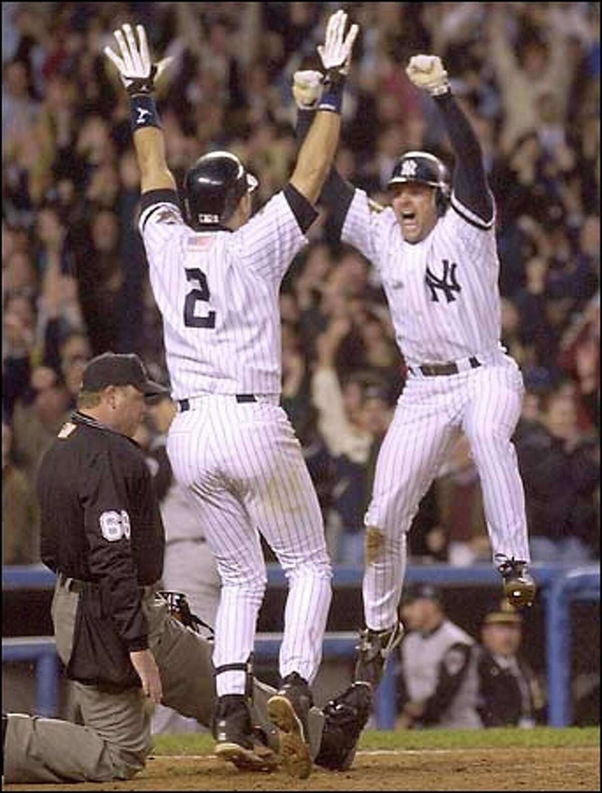 Chuck Knoblauch leaps into Derek Jeter's arms after scoring the winning run in the 12th inning of Game 5 of the World Series. The 3-2 victory gave the Yankees a 3-2 series lead. Game 6 is tomorrow.
