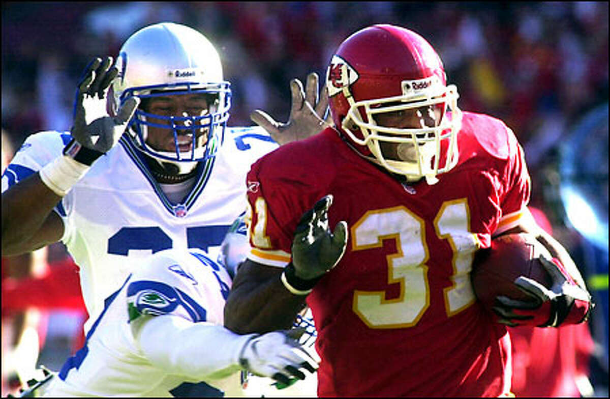 Kansas City's Priest Holmes ran for 120 yards on 26 workmanlike carries, with no run longer than 12 yards. Seattle's Reggie Tongue, back, and Shawn Springs pursue on this play.