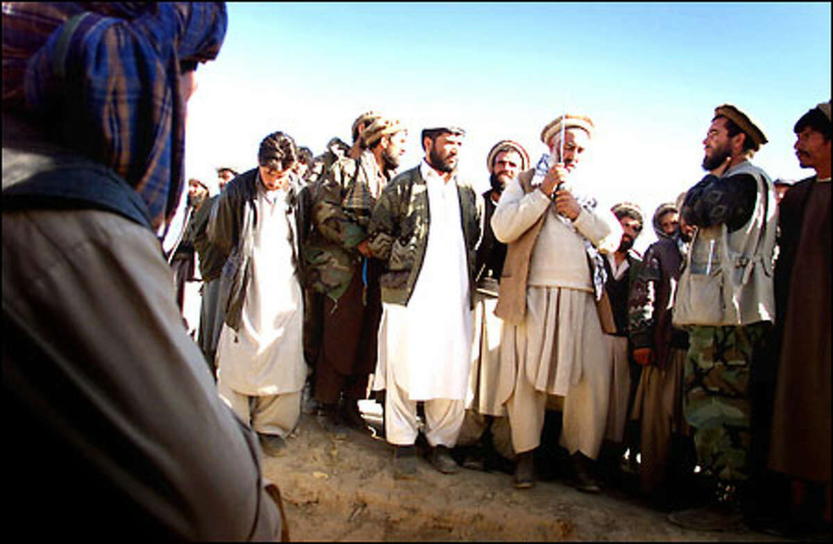 Alliance commander Hagi Shir Lam negotiates the final terms of a surrender of a suspected area of Taliban resistance south of Kabul, Afhganistan.
