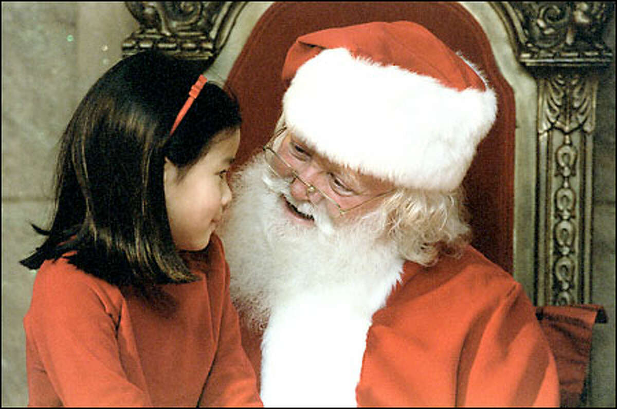 Santa, aka Bob Eldridge, listens to the Christams request of 7-year-old Carmen DeGiulio during her visit to the Bon Marche's North Pole display.