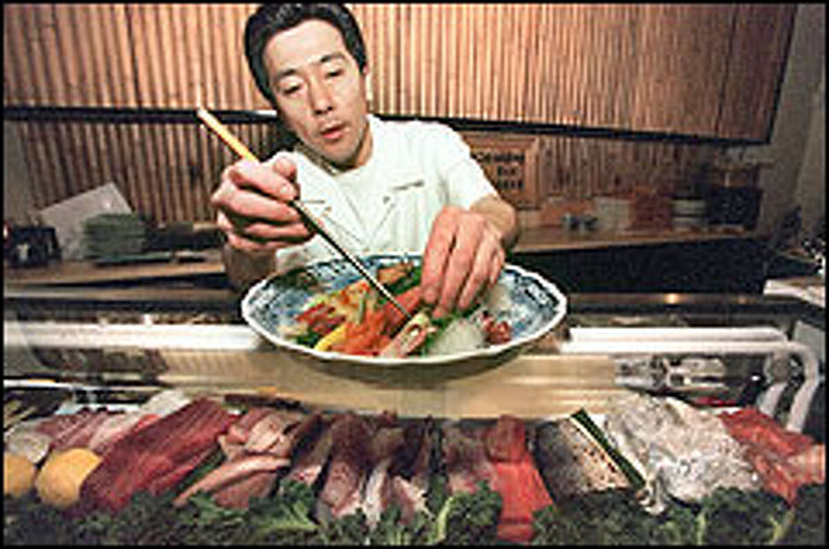 Yutaka Saito prepares a sashimi plate at Saito's Japanese Cafe and Bar, where freshness of food and cleanliness in preparation are obsessions.