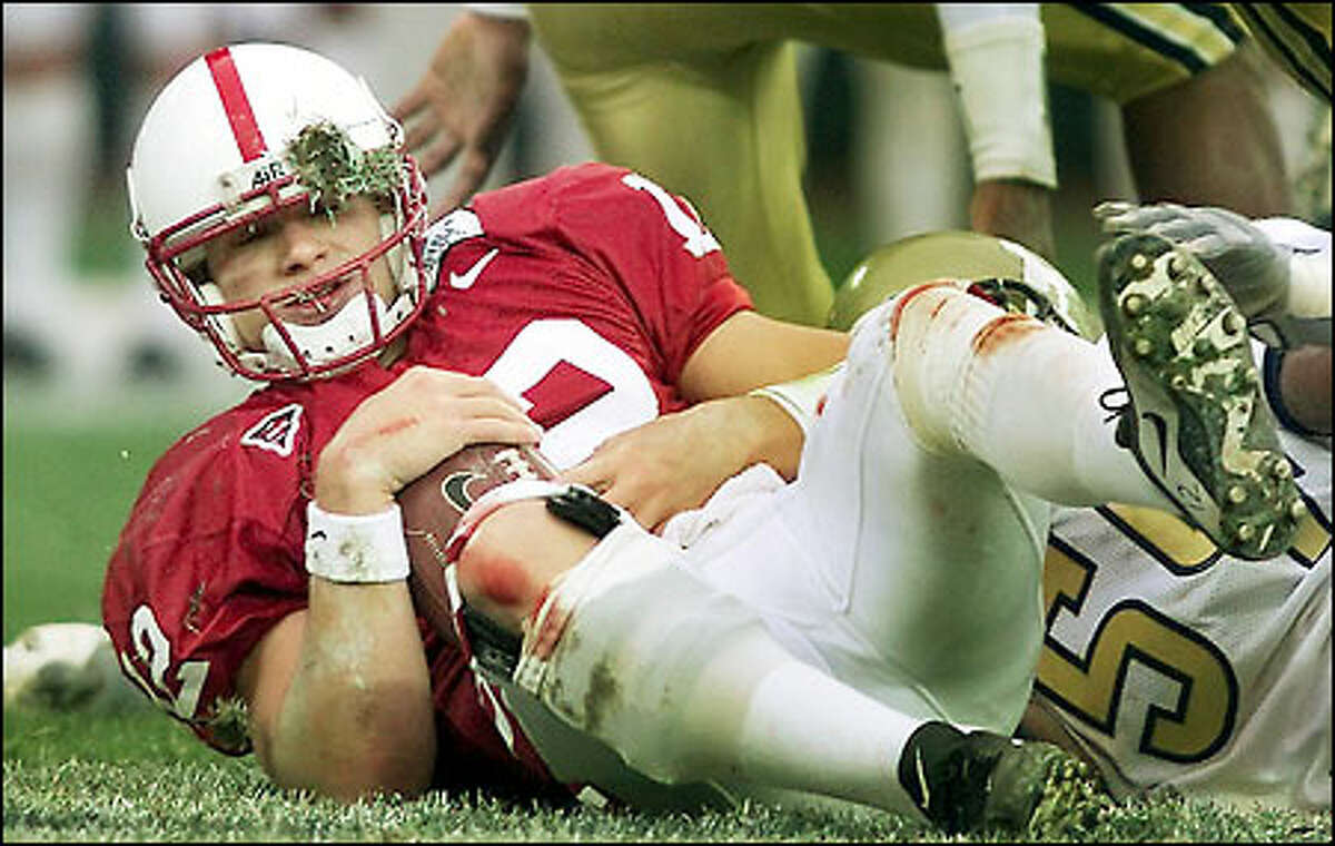With knees bloodied from the infield dirt and grass in his helmet, Stanford quarterback Randy Fasani gets up after rushing for short yardage in the third quarter, just before he was pulled.