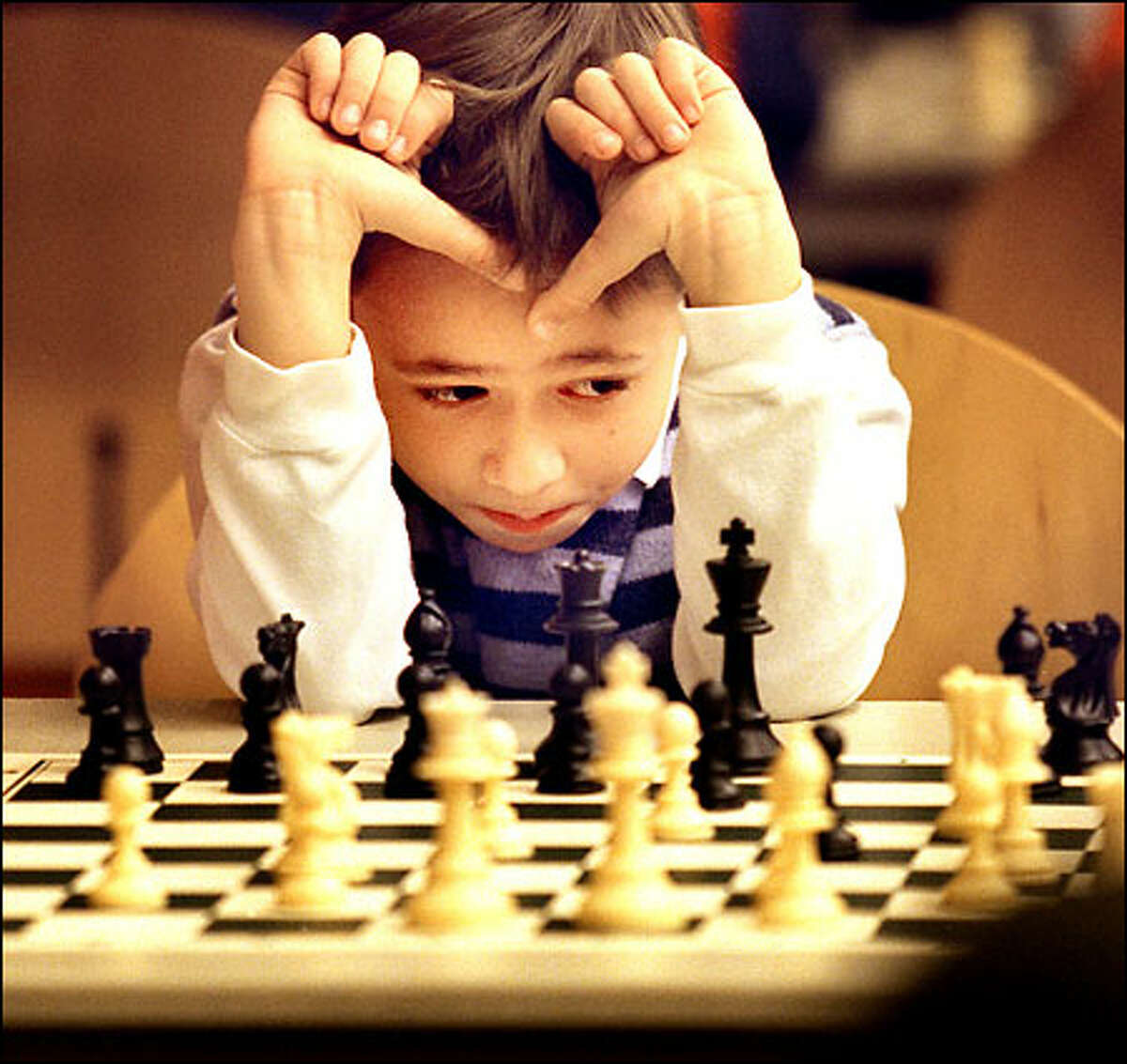 Derek Gasaway, 7, from Whittier Elementary School in Ballard concentrates while playing chess with Dr. Leo Stefurak at the Seattle Art Museum.