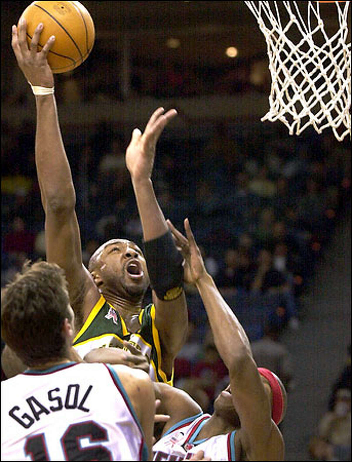 Vin Baker, who had six points and three rebounds, goes up for a shot as Memphis' Pau Gasol looks for help.