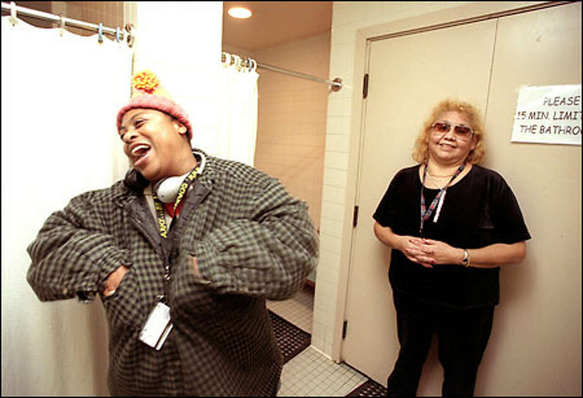 Dana Jackson, left, jokes with crisis-intervention specialist Aurelia, right, and some other friends at Angeline's Day Center, a refuge for homeless women, as she gets ready to use the shower. Jackson has spent three months homeless in Seattle because her job and place to live fell through after she moved here from Stockton, Calif.