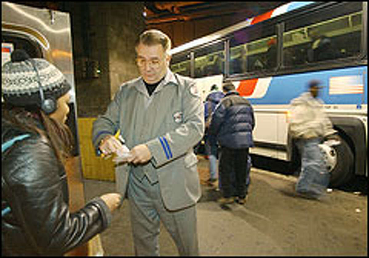 Driver William Power processes a ticket for a woman boarding a bus in New York City. Since Sept. 11, many long-distance travelers, are opting for the bus over air travel.