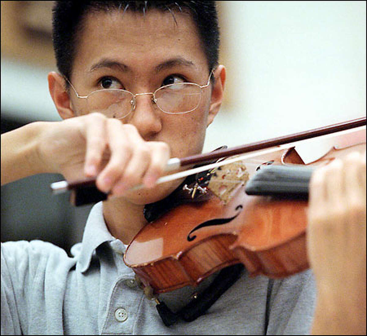 J.J. Jang rehearses with the orchestra at Lynnwood High School. Jang was selected to perform in a concert tomorrow at Carnegie Hall in New York.