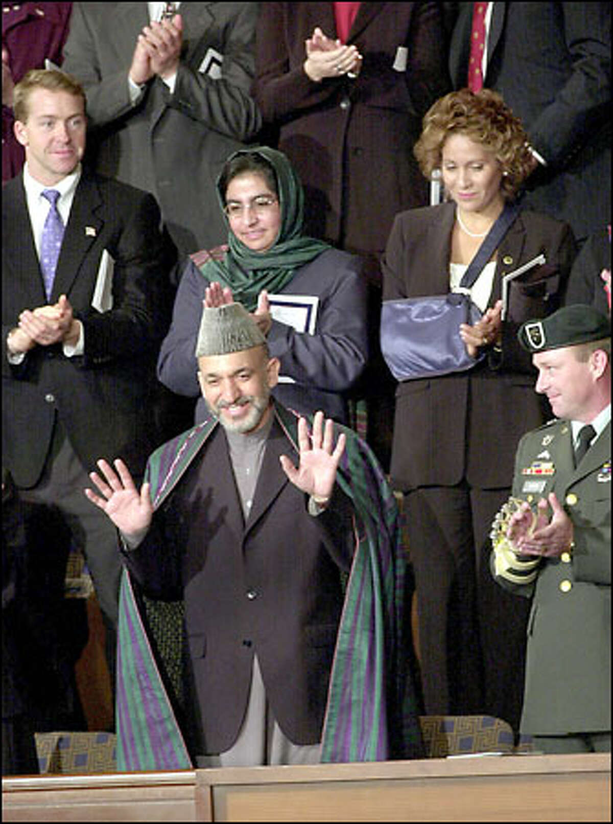 Afghan leader Hamid Karzai acknowledges applause. From left are Winter Olympics skeleton contestant James Shea; Sadoozai Panah, Afghanistan's managing director for women's development; Hermis Moutardier, a flight attendant from American Airlines Flight 63, on which the shoe-bomb suspect was subdued; and Sgt. 1st Class Ronnie Raikes, who was wounded in Afghanistan.