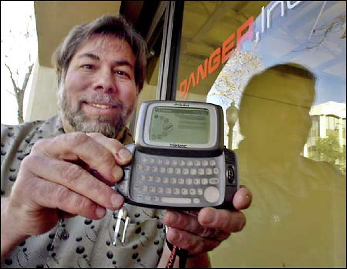 Apple Computer co-founder Steve Wozniak, a member of the board of directors of Danger Inc., displays Danger's multifunction hand-held device.