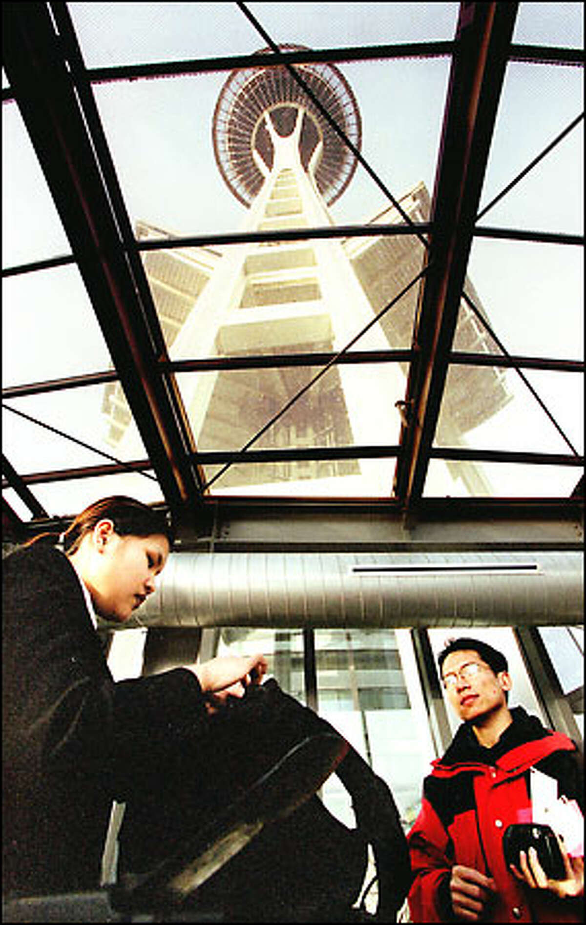 Space Needle security officer Tokyo Phengphachanh, left, searches the bag of tourist William Hsu of New Westminster, B.C., on the entrance ramp to the Seattle landmark. Bag searches began after Sept. 11.