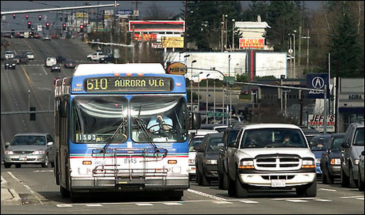 The No. 610 bus waits at a signal light at 220th Street Southwest and state Route 99 after Sunday service resumed yesterday after a two-year hiatus created by Initiative 695.