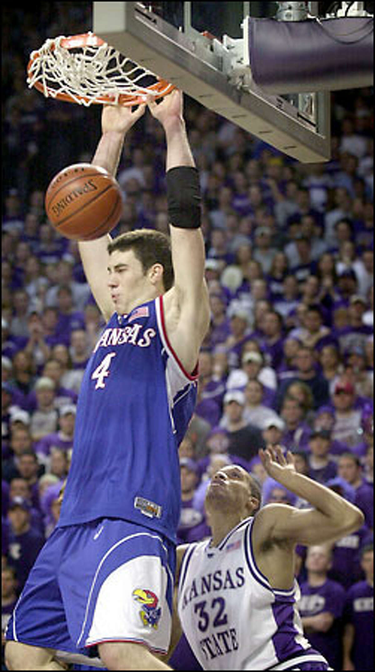 Kansas forward Nick Collison hammers down two of his 15 points in the first half as Kansas State guard Gilson DeJesus can only watch.
