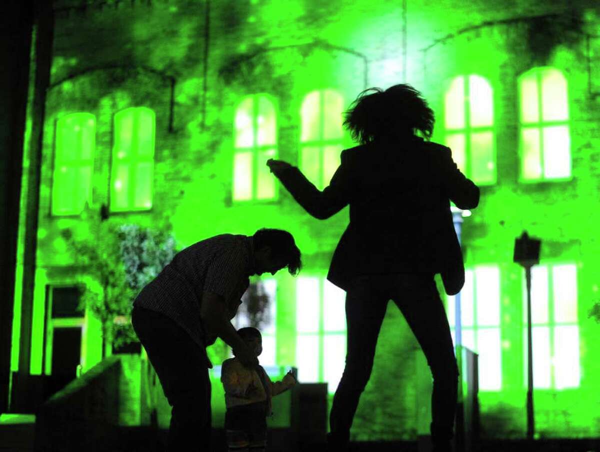 Aura Moreno dances on the lawn by the Magik Theatre as a 3D projection mapping display by Scott Justis of LD Systems is projected during a dress rehearsal Friday, March 11, 2011, in preparation for Saturday's Luminaria.