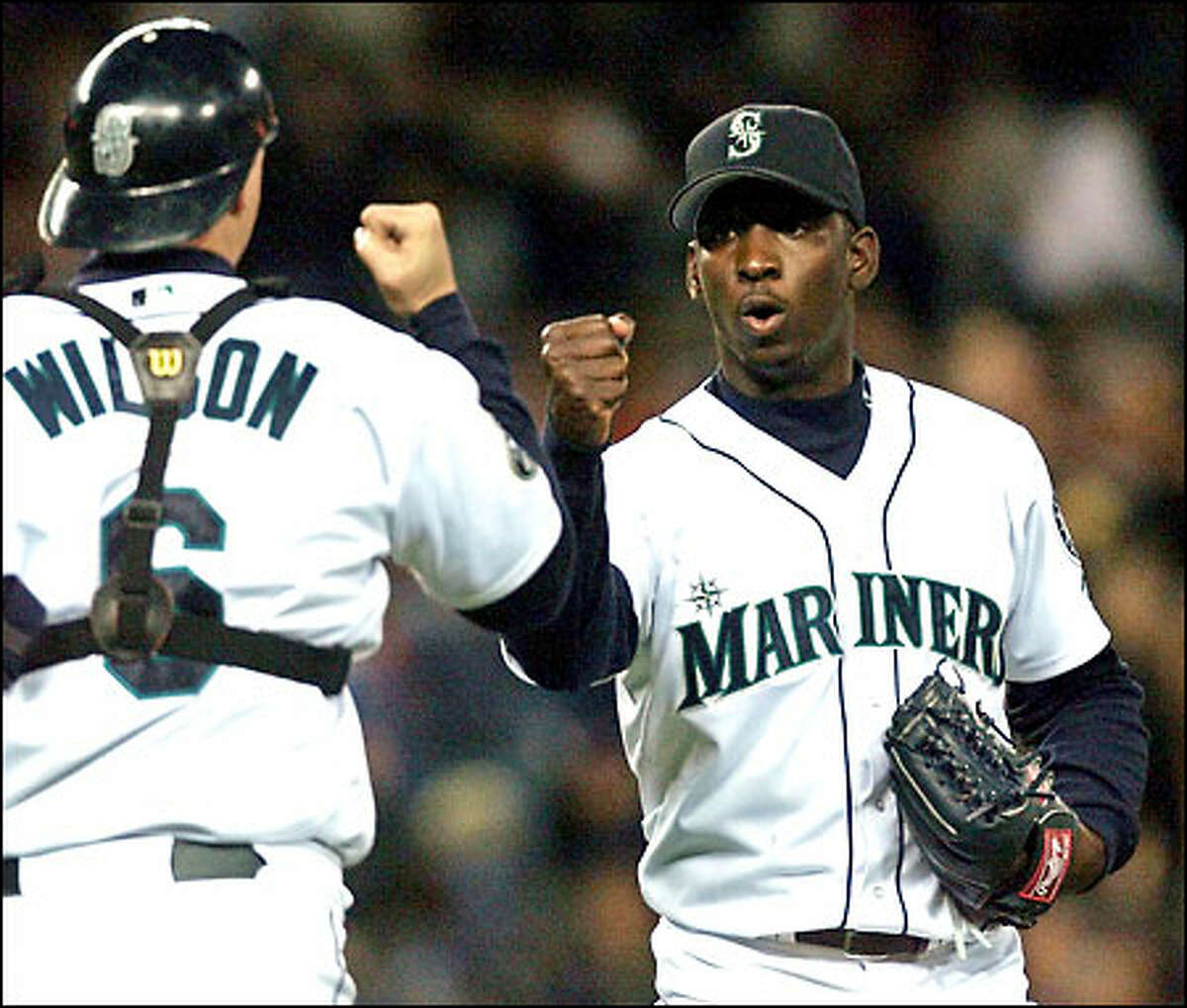 Dan Wilson gives Rafael Soriano a celebratory fist-bump after the rookie right-hander recorded his first save in the Mariners 7-2 victory. Soriano pitched three scoreless innings, allowing two hits.