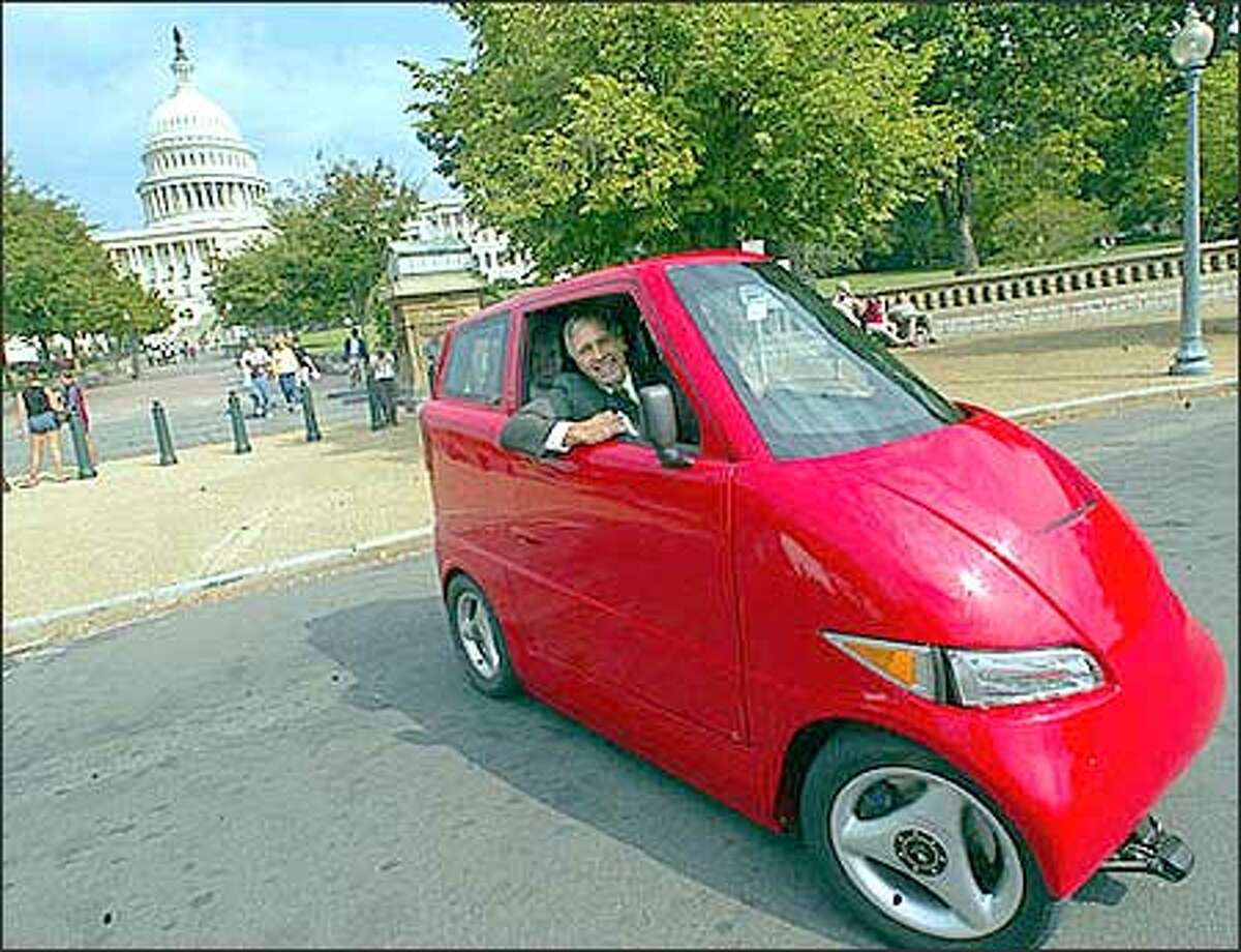 Rep. George R. Nethercutt, R- Wash., looks out from the electric and low-emission vehicle Tango Wednesday, Sept. 18, 2002, near the U.S. Capitol. The Tango, manufactured by Commuter Cars Corp. of Spokane, is narrower than a Honda Goldwing motorcycle and accelerates faster than a Dodge Viper. (AP Photo/Rick Bowmer)