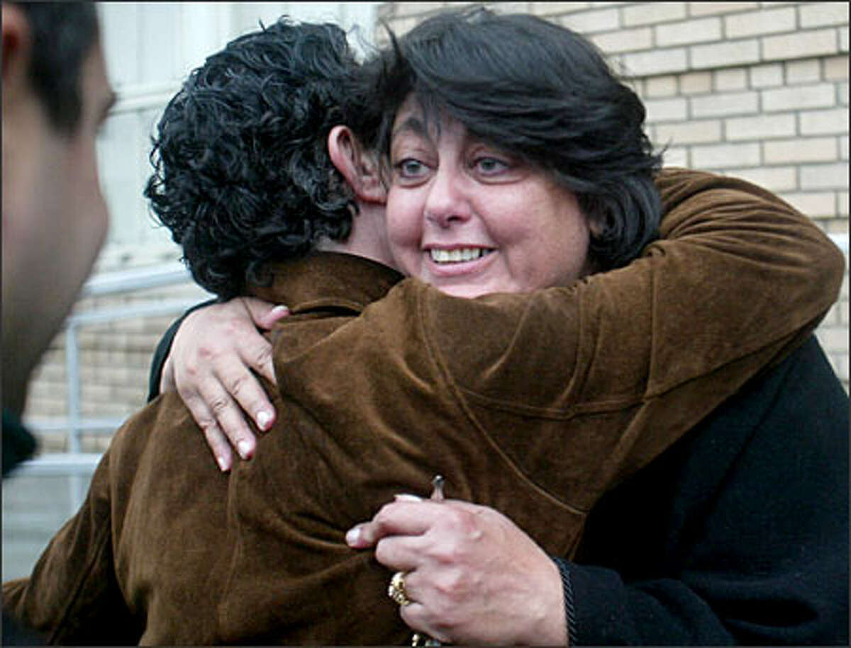 Rita Zawaideh, of the Arab American Community Coalition, gets a hug on the steps of the INS Detention Center, after Hanan Ismail and her daughter, Nadin Hamoui, were released.