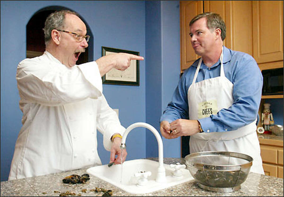 Sharing a kitchen with enthusiastic chef Robert Reynolds is a full-course learning experience. Reynolds, left, jokes with former student Jim Ewel while the two clean mussels at Ewel's home. Portland-based Reynolds will host a dinner Sunday in Seattle.