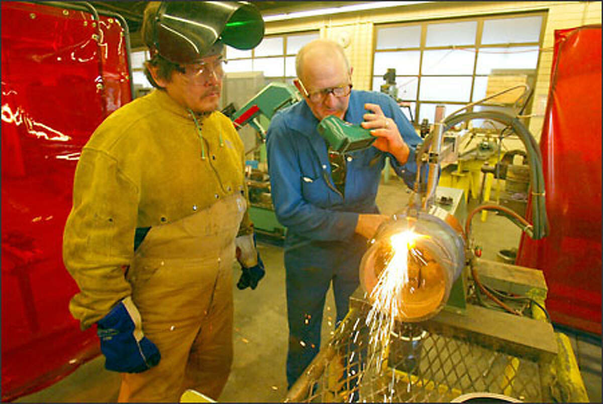 John Jefferson (left), a member of the Lummi Nation, is learning to become a pipe weldor at Bellingham Technnical College. Here he is instructed in the use of a oxy-acetylene pipe cutting machine by volunteer instructor Charles Eaton. Jefferson is going to spend some time in jail and be banished from his tribe for continued drug offenses.