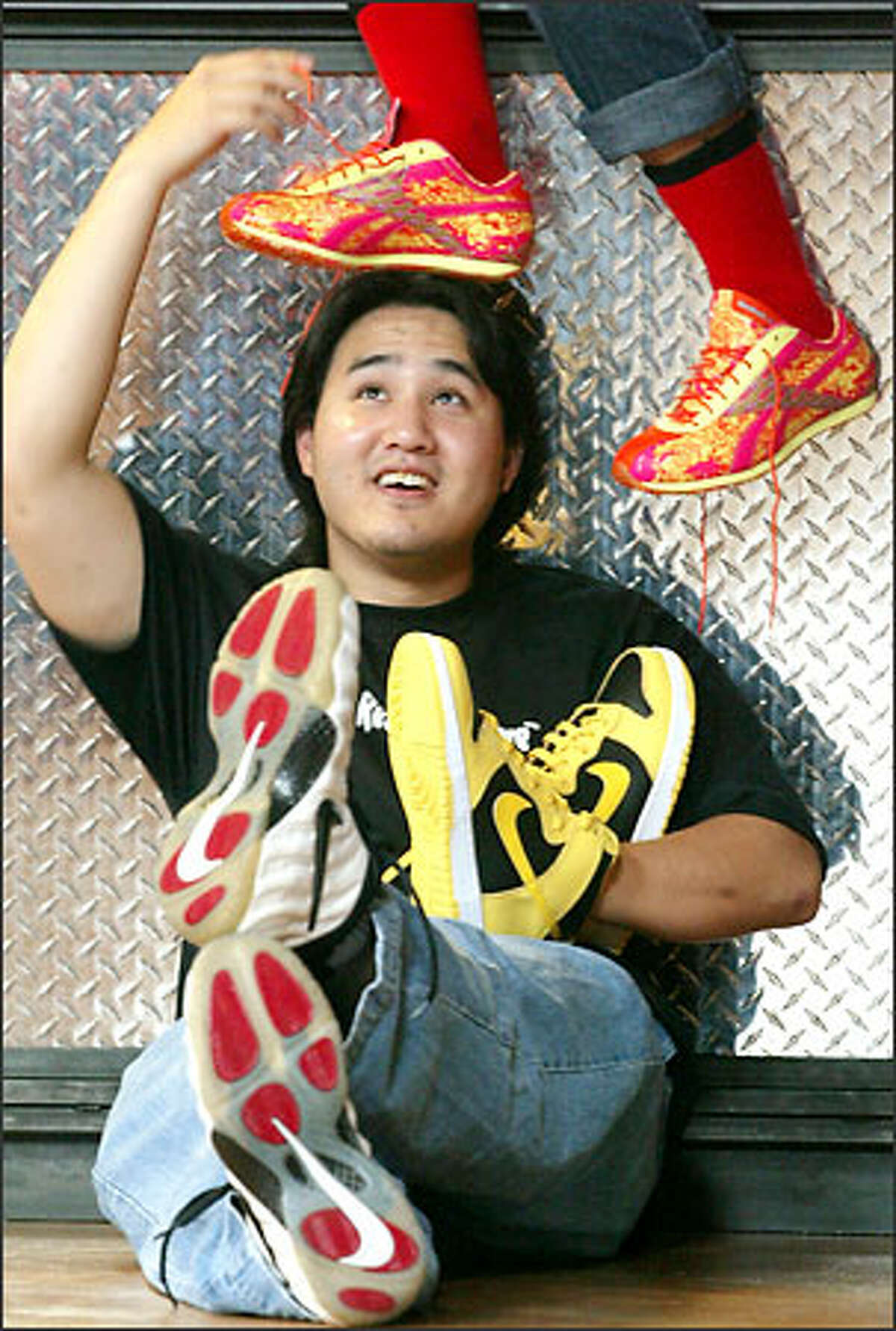 Mark Shin with sneakers from his collection: orange-and-yellow Reebok Gold Medalists, yellow Nike Dunk NYCs and, on his feet, Nike Air Foamposites.