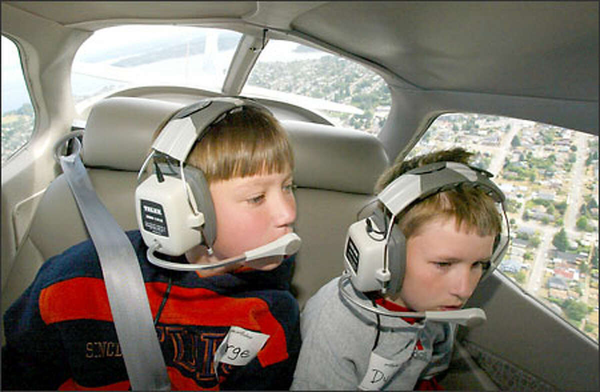 George Kamerzan, left, and Dylan Mullen, both 11, get a bird's-eye view of Seattle from the window of a Cessna during an aviation camp this week.
