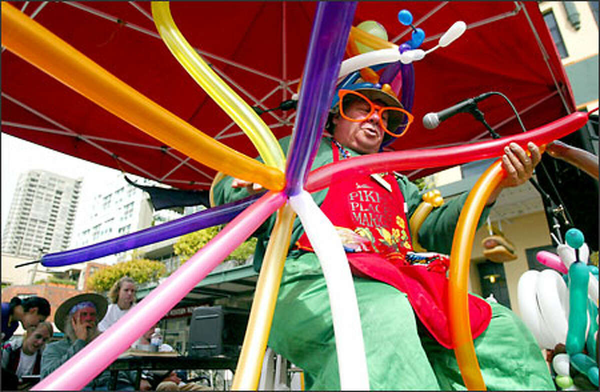 Twister Thomas, aka Thomas Farrell, makes an elaborate balloon sculpture on one of three stages at the Pike Place Market during the second annual Buskers' Festival.