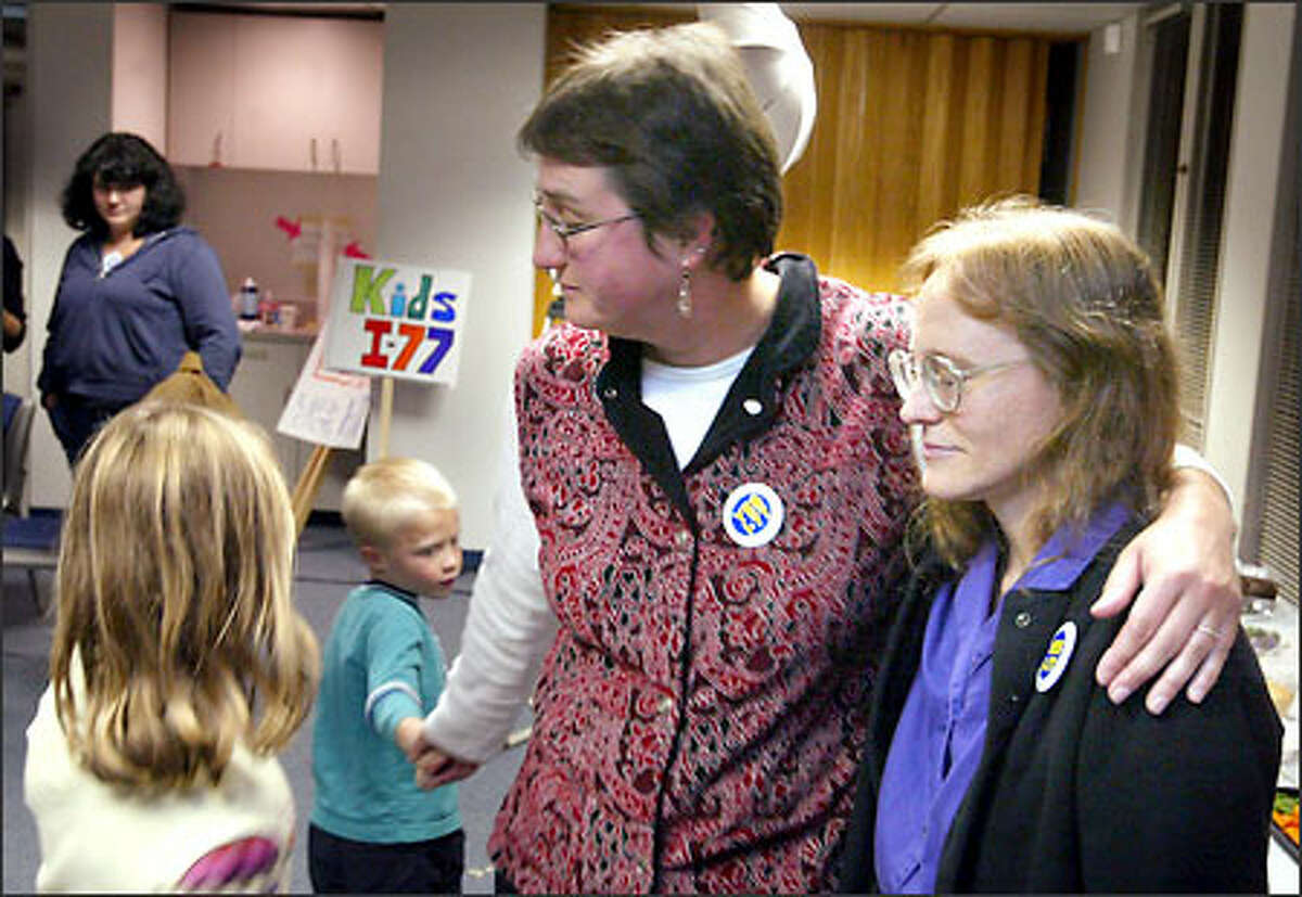 Dorothy Gibson, center, a supporter of the espresso tax measure, is consoled by her children, Simon Gibson-Penrose and Isabel Gibson-Penrose, and hugs fellow supporter Betty Williams as early returns show voters rejecting Initiative 77.