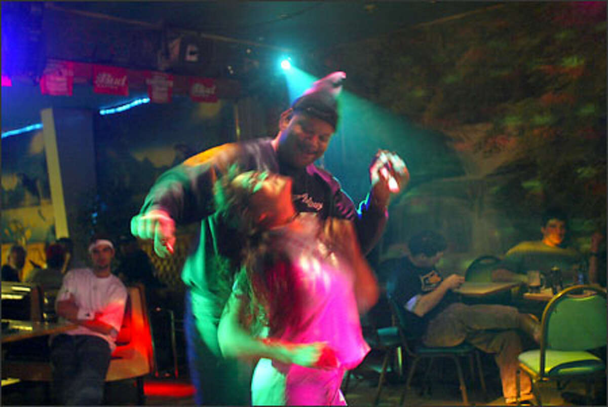 Ralph Harvey, a cargo agent for Penn Air Alaska Airlines, dances with Barbara Miles at Carl's in Unalaska. For the past 20 years, the town has tried to shed its Wild West image.
