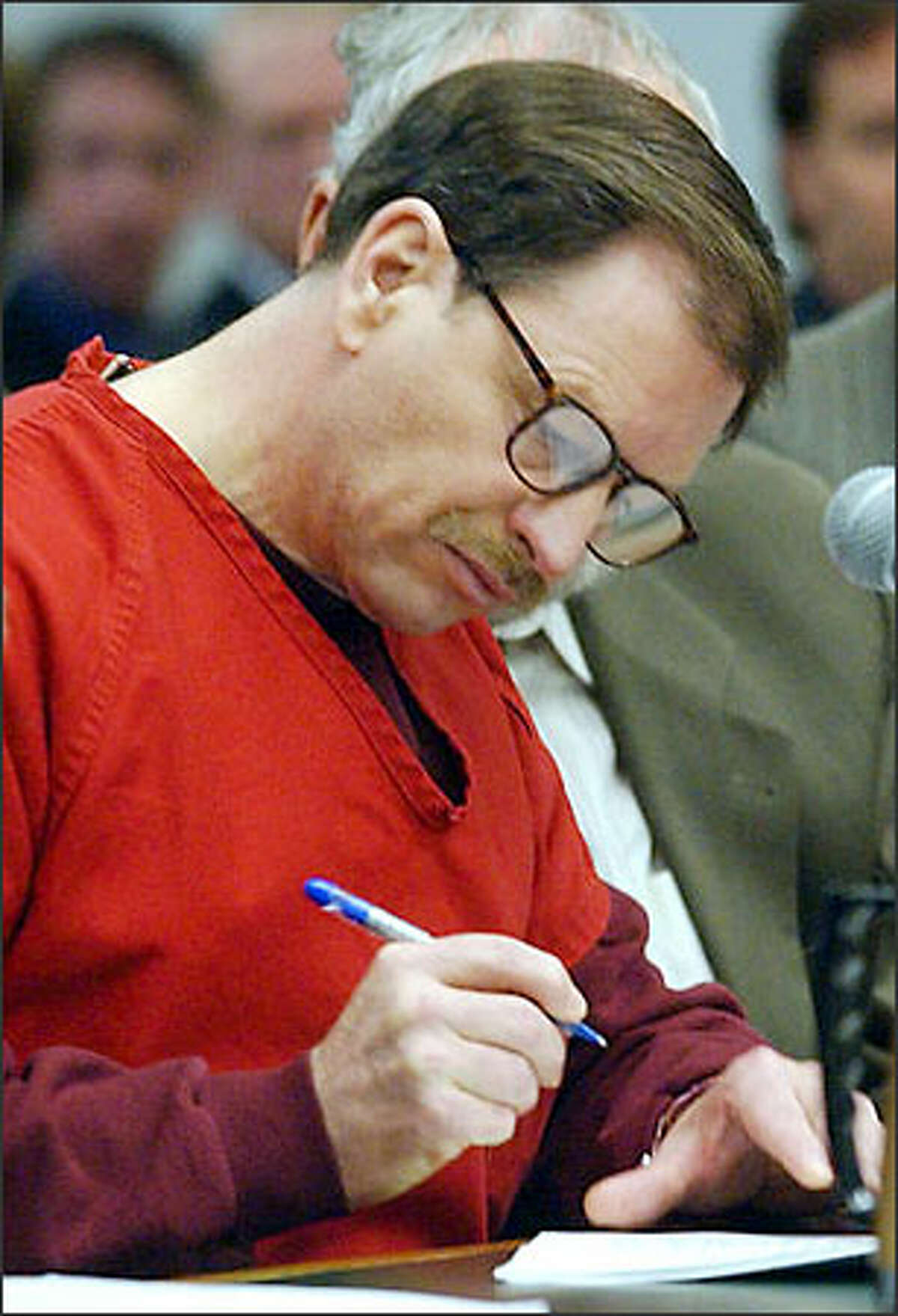 Green River Killer Gary Ridgway listens as individual guilty pleas are read on Tuesday, November 5, 2003, in the King County Courthouse in Seattle. Defense attorney Anthony Savage is at right. Ridgway pleaded guilty to 48 counts of murder.