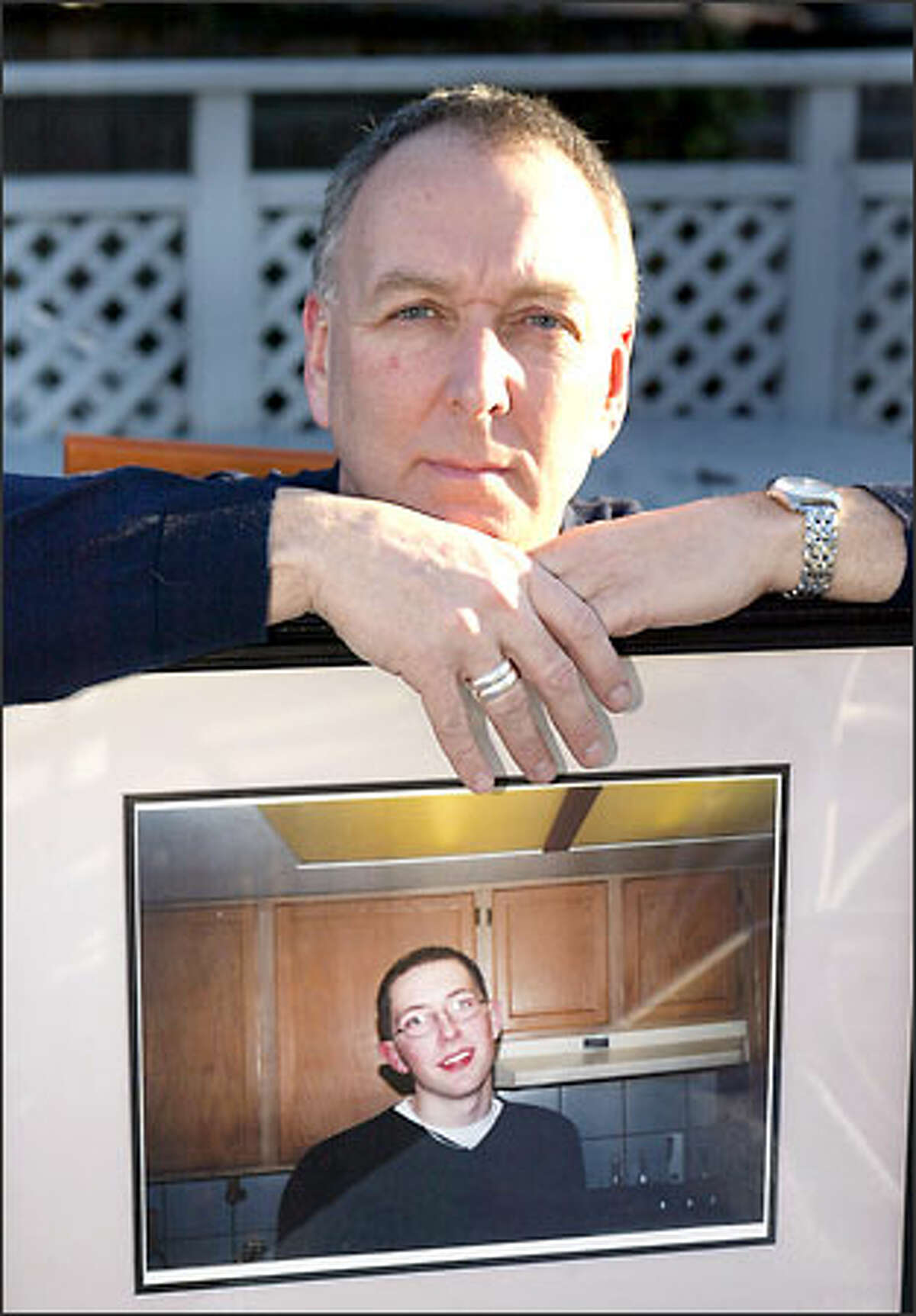 George Fraser holds a picture of his son Geoff, who was killed by a drunken driver. Fraser is wearing two silver rings on his right hand that Geoff wore. Fraser and others believe that their talks to drunken drivers help to save lives or change behaviors by making a lasting impression.