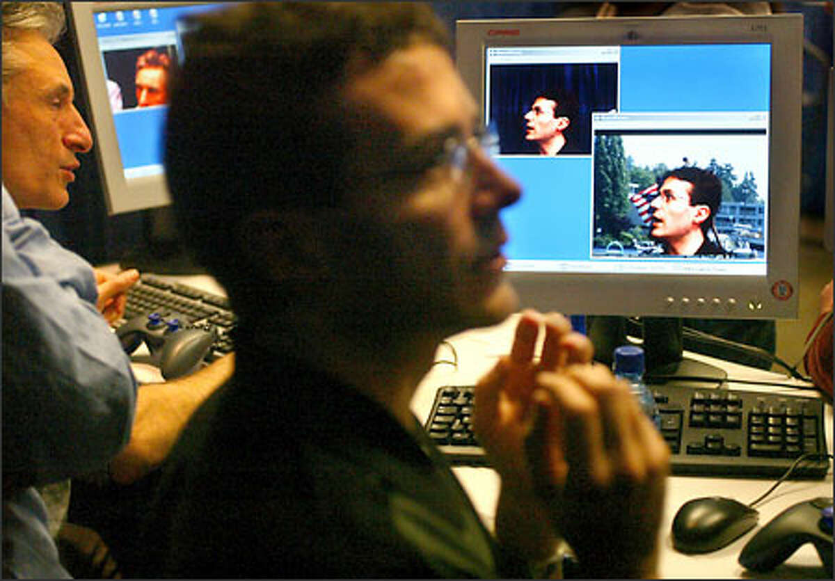 Antonio Criminisi, foreground, and Andrew Blake of the Microsoft Research office in Cambridge, England, demonstrate a program called i2i:3D Visual Communication, which uses two cameras to distinguish the primary speaker from the other parts of the picture tracking a person.