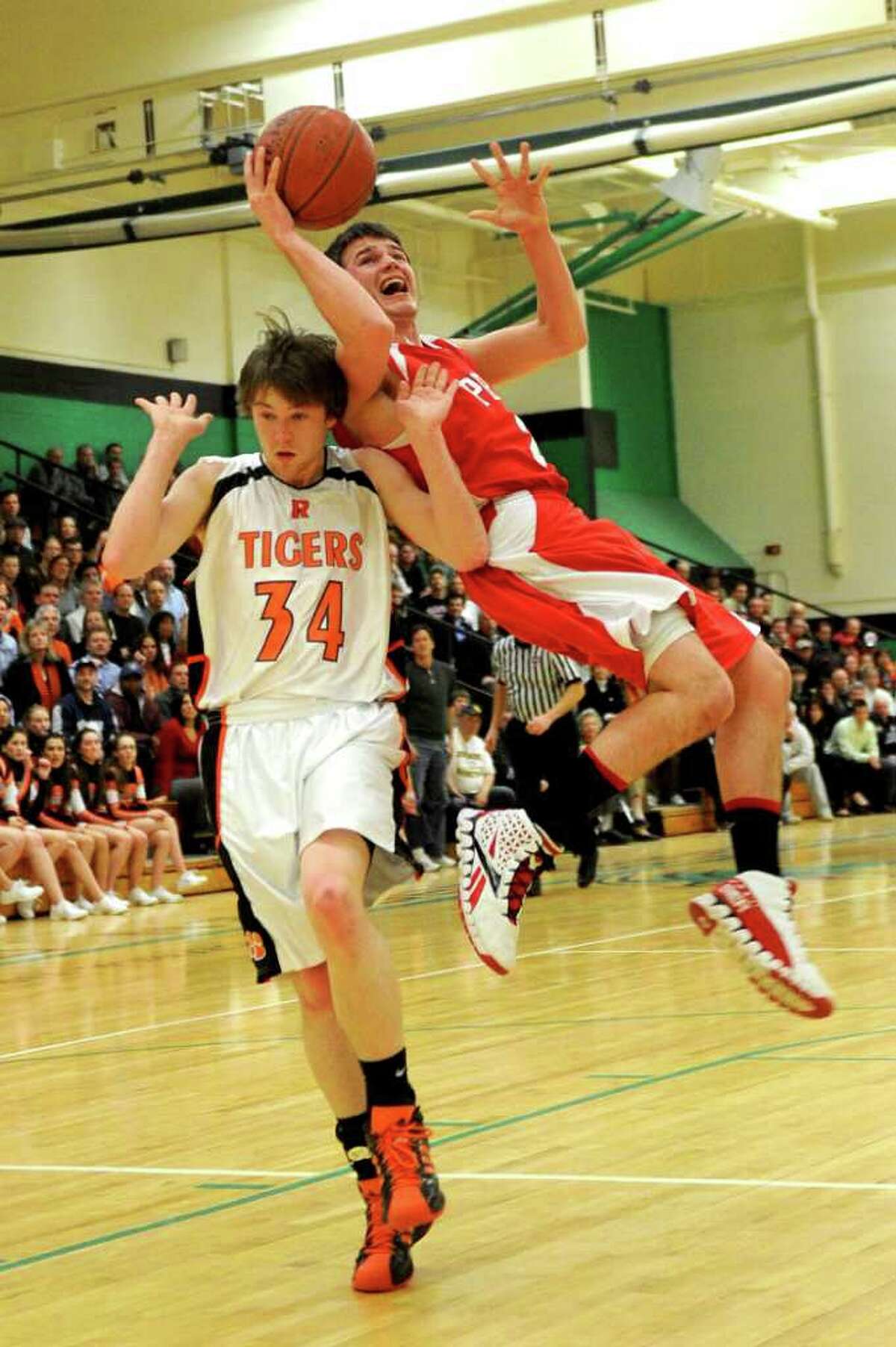 Fairfield Prep's Robbie Bier is fouled by Ridgefield's Bryan Galvin during Tuesday's class LL semifinal game at Wilby High School in Waterbury on March 15, 2011.