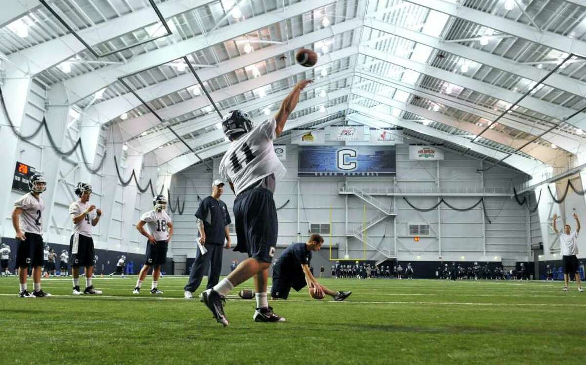 Connecticut quarterback Scott McCummings (11) throws as quarterbacks Michael Nebrich (2), Michael Box (4), and Johnny McEntee (18) look on during the first day of spring NCAA college football practice in Storrs, Conn., Tuesday, March 15, 2011 (AP Photo/Jessica Hill)