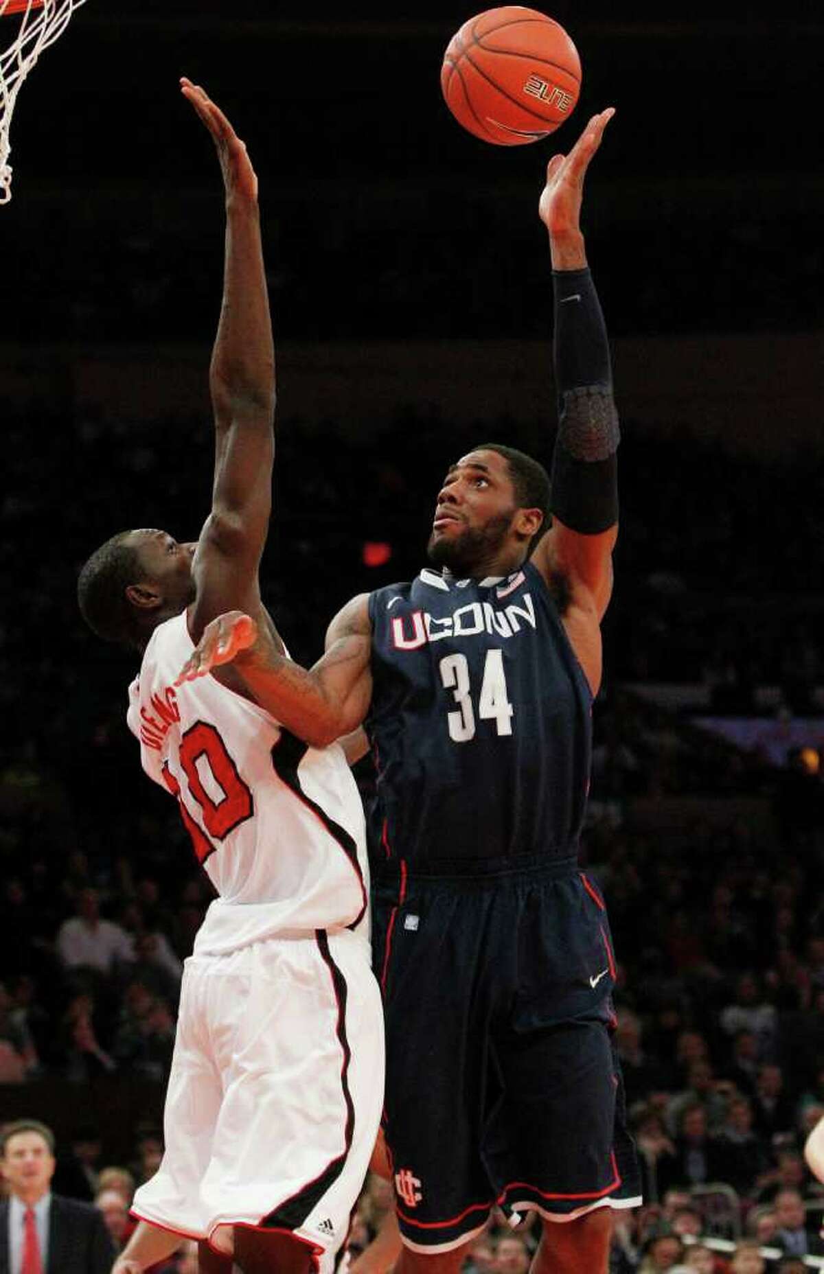 Connecticut's Alex Oriakhi (34) shoots over Louisville's Gorgui Dieng (10) during the first half of an NCAA college basketball game at the Big East Championship ,Saturday, March 12, 2011, in New York. (AP Photo/Frank Franklin II)