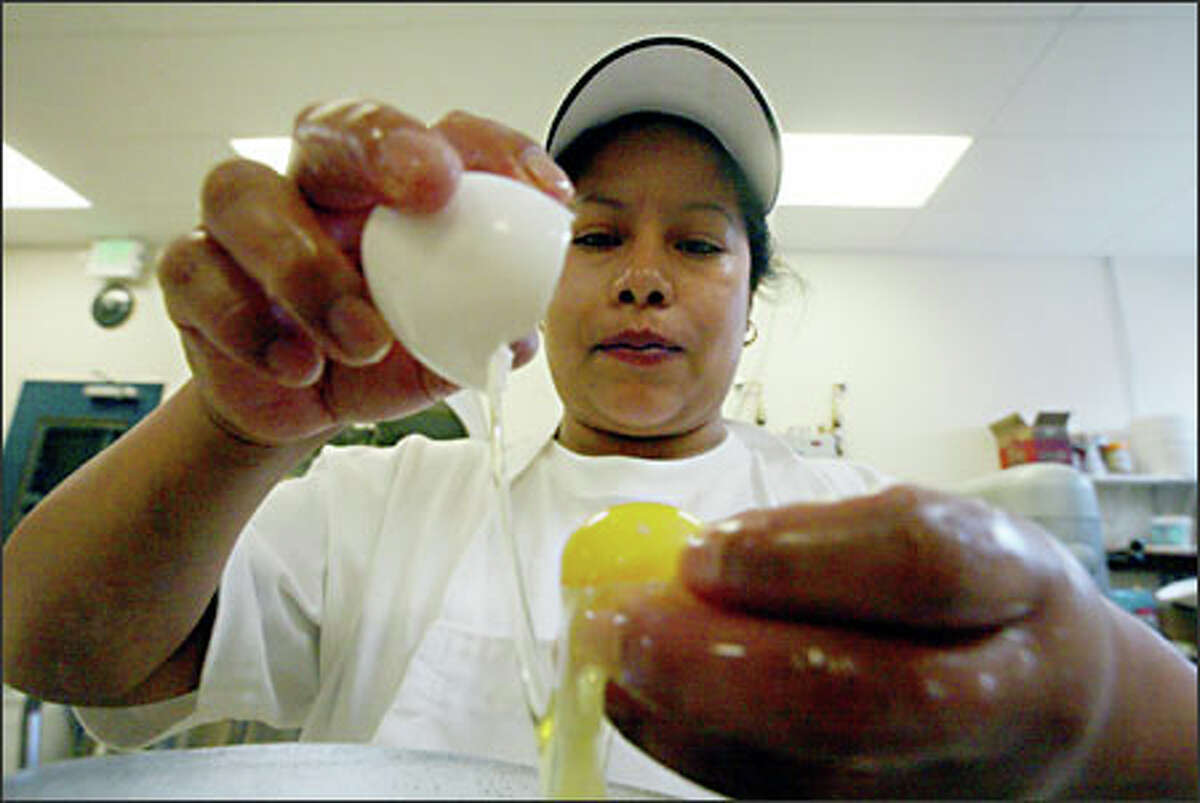 Isabel Rocio Roiz Cortes, a baker at Despi Delite Bakery on Beacon Hill, separates eggs at the store's new location, a former dry cleaning business.