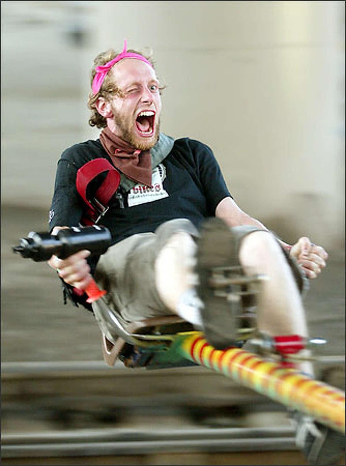 With just enough strength left to keep hold of the beer in his water bottle, Herman Beans rides a pedal-powered centrifuge during the party after the weekend's Eighth Annual Downhill and Messenger Challenge.